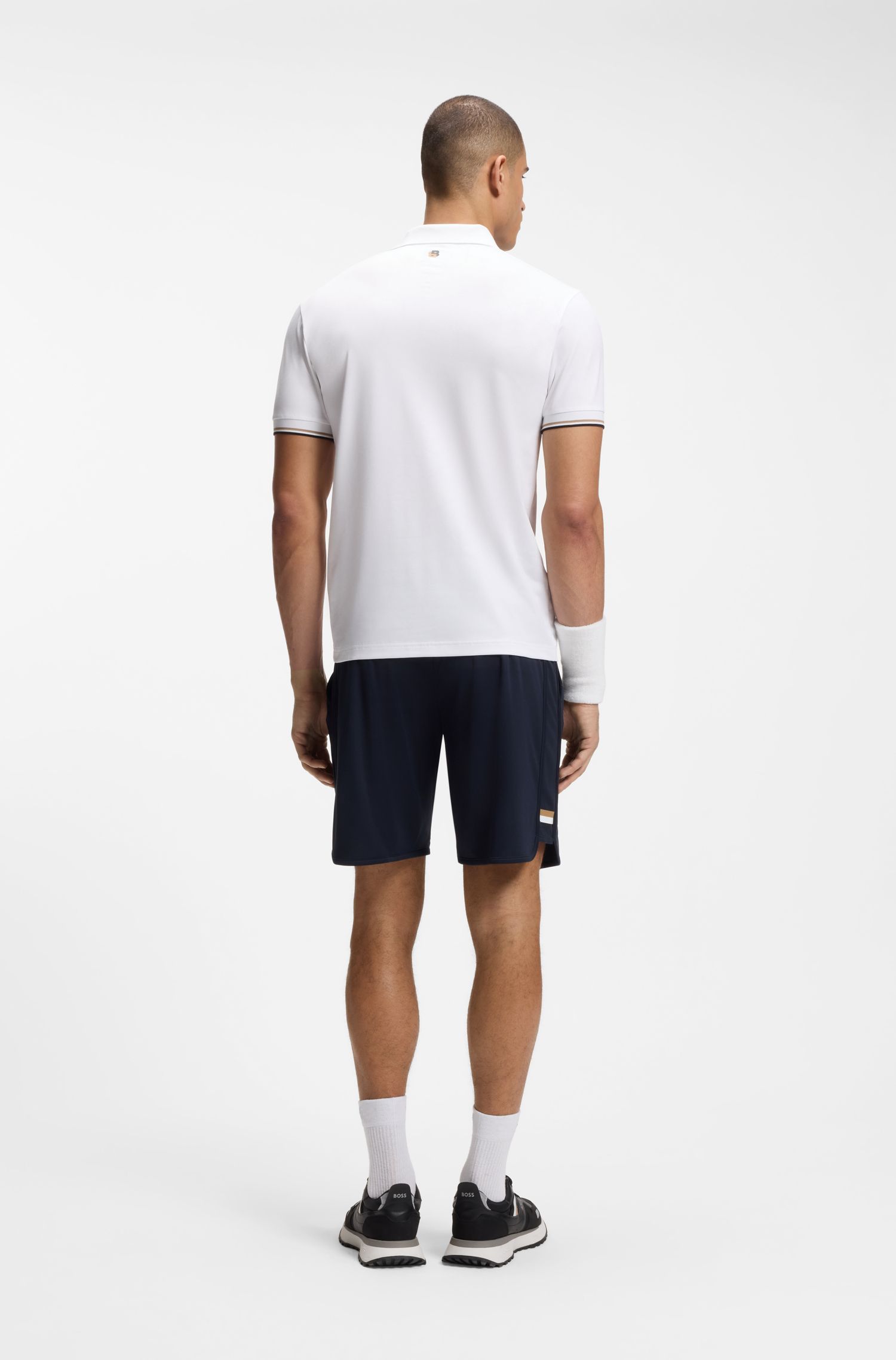 Áo polo dáng ôm năng động với họa tiết quả bóng tennis dập nổi.