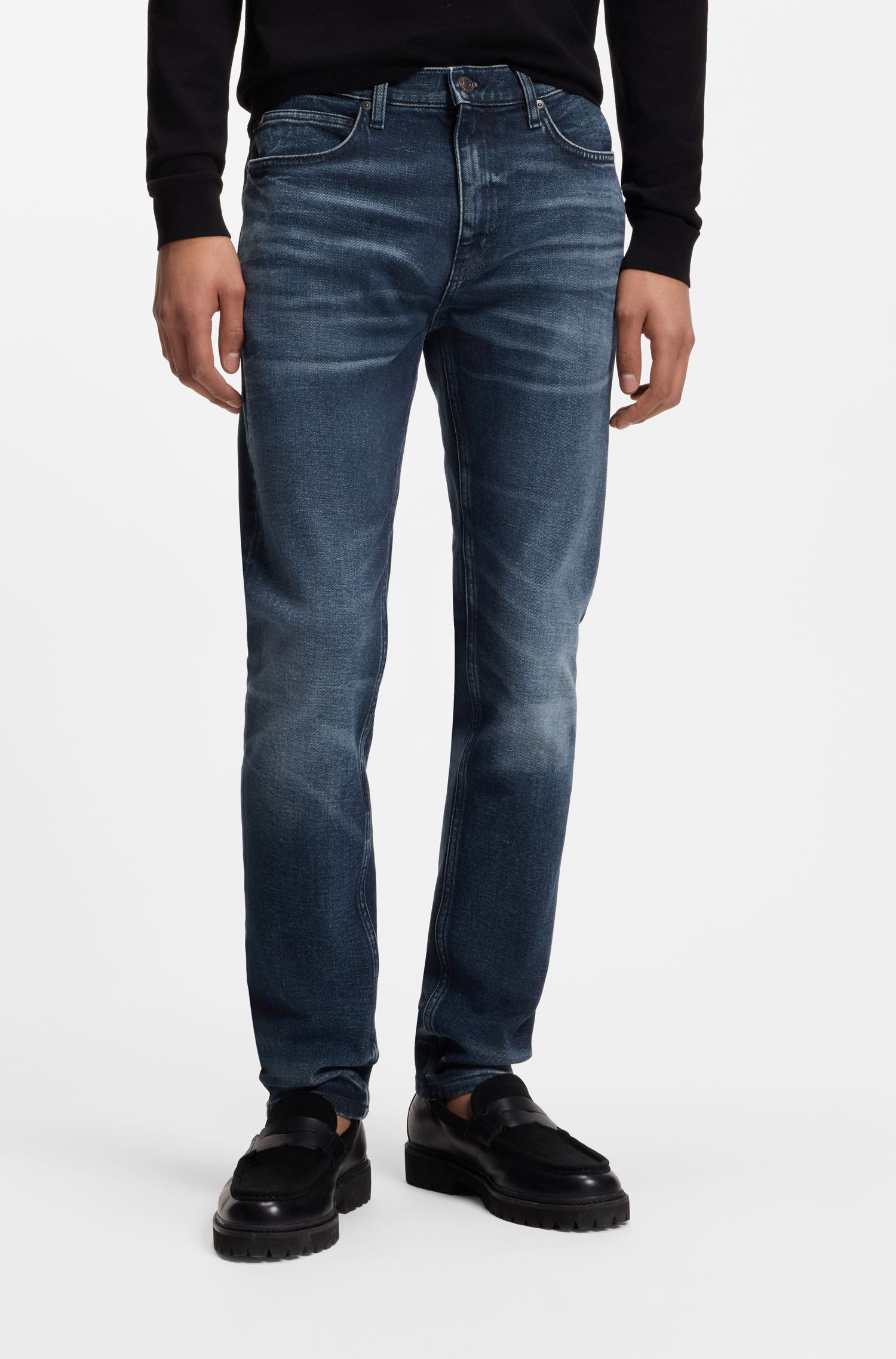 Quần jeans dáng ôm sát màu xanh đậm, chất liệu denim co giãn.
