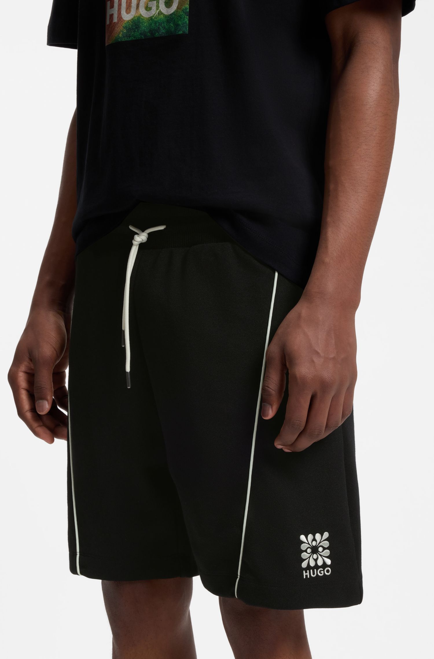 Quần short pha cotton với họa tiết logo thêu.